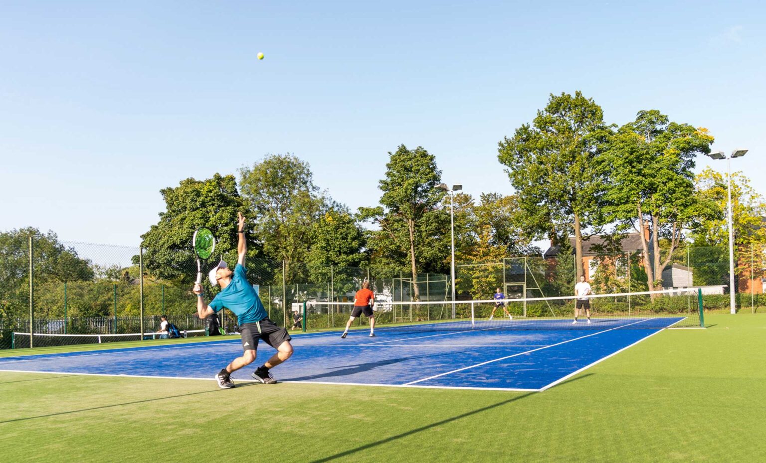 Club tennis players on astroturf tennis court in UK
