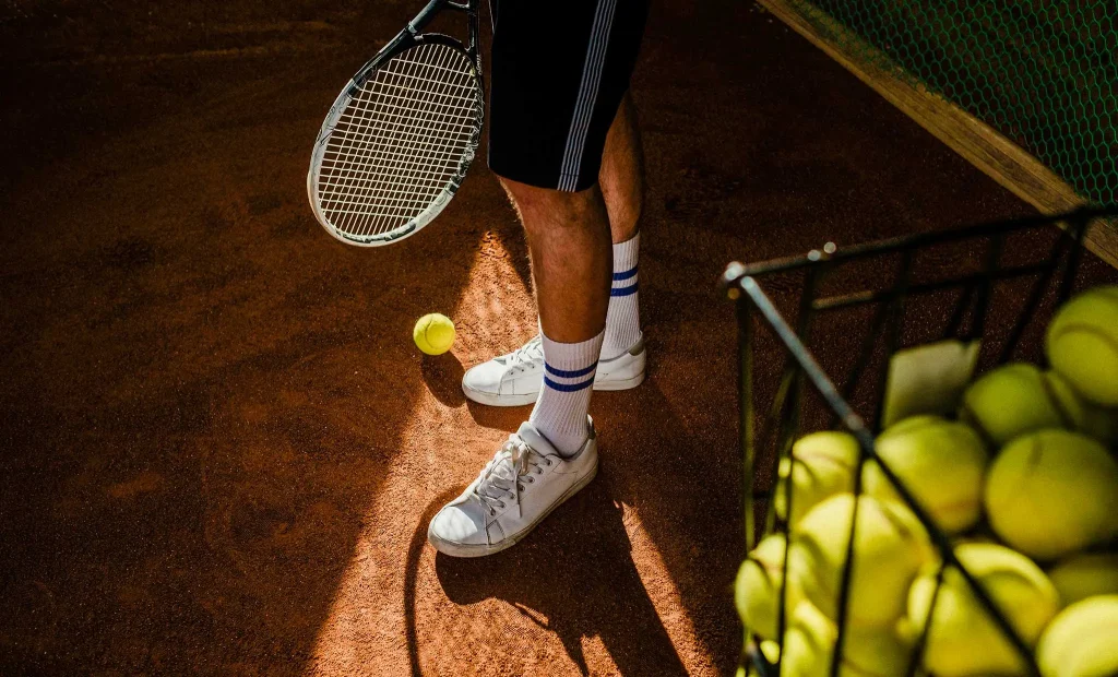 Tennis players practicing tennis serve with a basket of balls