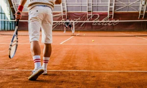 Tennis player preparing to hit a serve during a match on clay