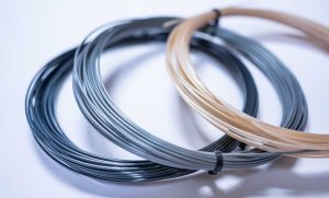Photo of different types of tennis strings on white background